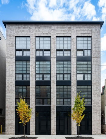 Front view of a modern four-story building with large windows.