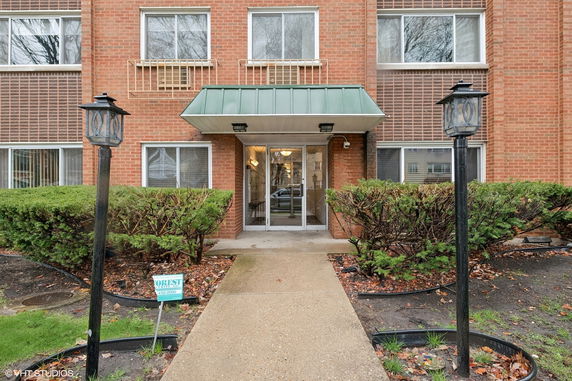 Front view of a building with a green canopy entrance and brick exterior.