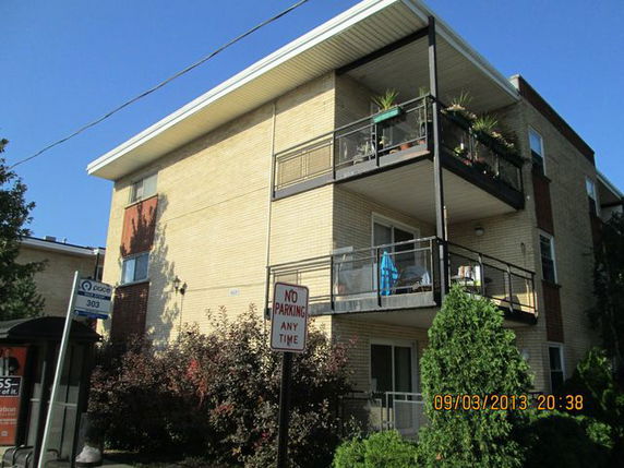 Front view of a three-story apartment building with balconies.