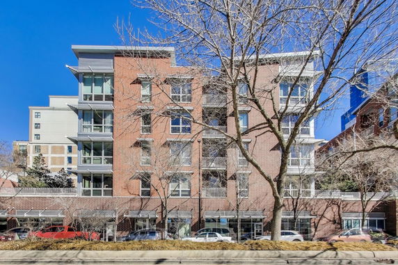 Front view of a multi-story brick building with large windows and balconies.