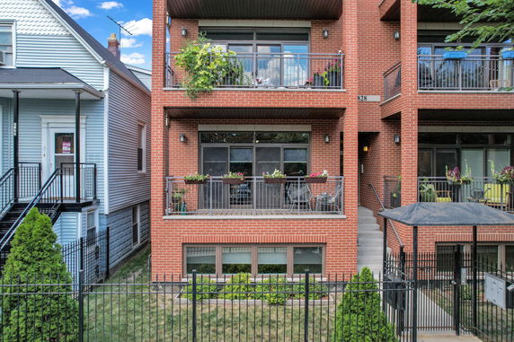 Front view of a brick apartment building with multiple balconies.