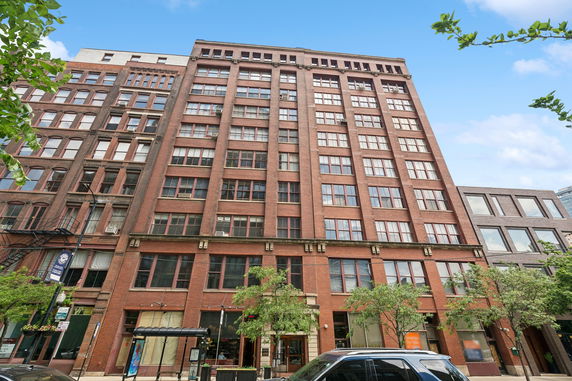 Front view of a multi-story brick building with large windows.