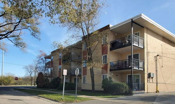 Front view of a three-story apartment building with balconies.