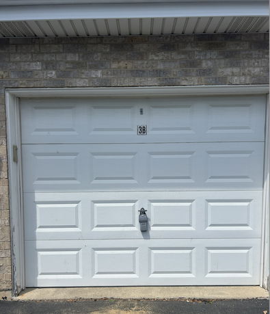Front view of a garage door attached to a brick building.
