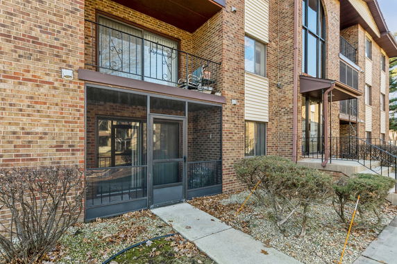 Front view of a multi-story brick apartment building with balconies.