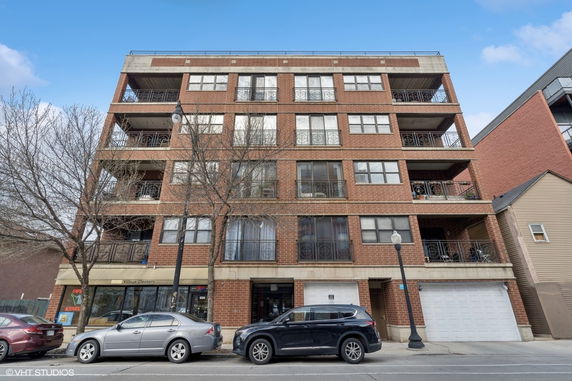 Front view of a multi-story brick building with balconies.
