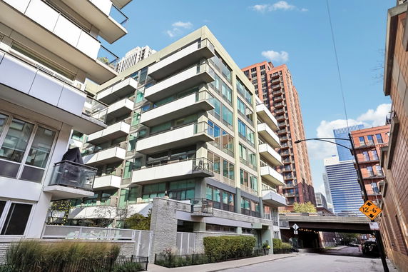 Front view of a modern multi-story apartment building with balconies.