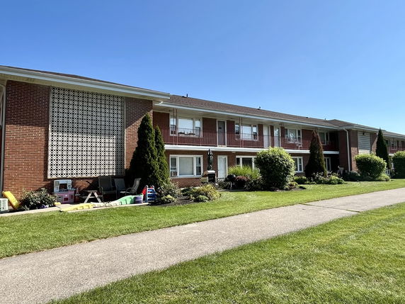 Front view of a two-story brick apartment building with balconies.