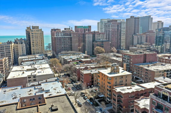 Aerial panoramic view of a cityscape with multiple high-rise buildings near a body of water.
