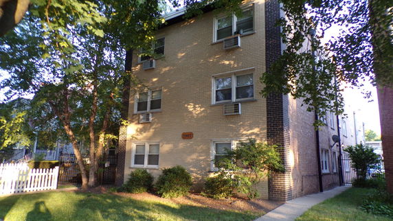 Front view of a multi-story brick apartment building.