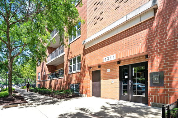 Front view of a multi-story brick building with balconies.