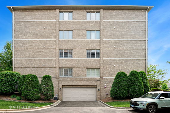 Front view of a multi-story building with brick exterior and large garage door.