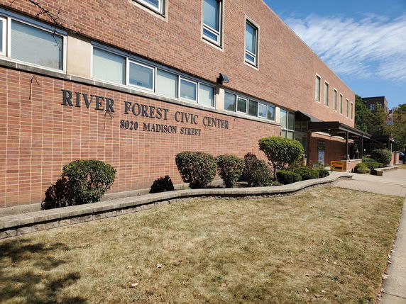 Front view of a brick civic center building with multiple windows.
