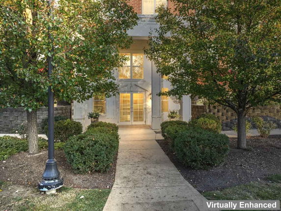 Front view of a building entrance with surrounding trees and bushes.