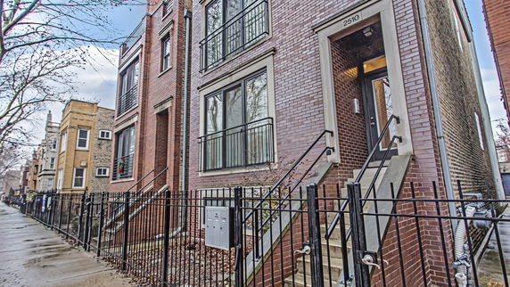Front view of a multi-story brick building with steps leading to the entrance.