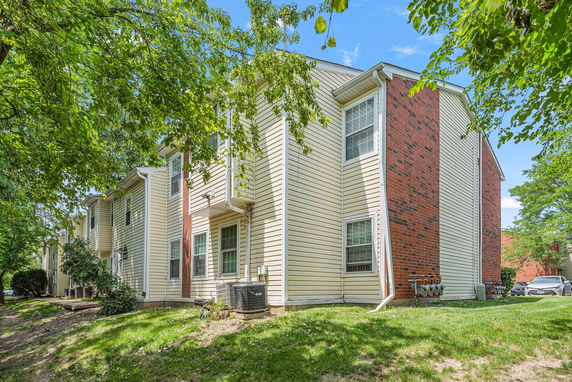 Side view of a residential building with brick and siding exterior.