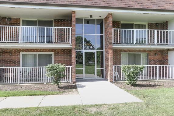 Front view of a brick apartment building with balconies.