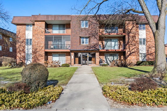 Front view of a multi-story apartment building with balconies.