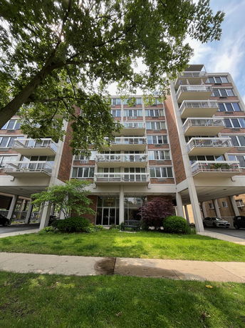 Front view of a multi-story apartment building with balconies.