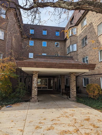 Front view of a multi-story brick building with a covered entrance.