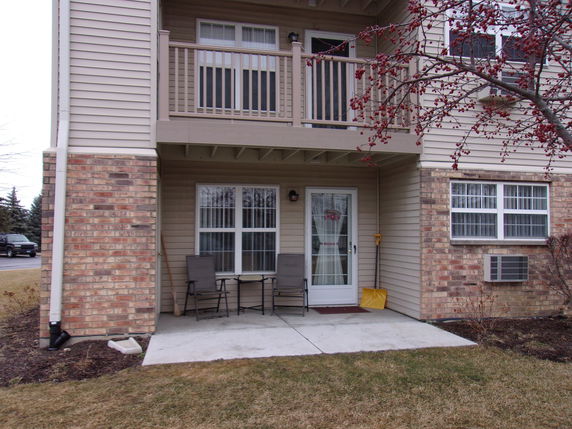 Front view of a two-story house with a porch and balcony.