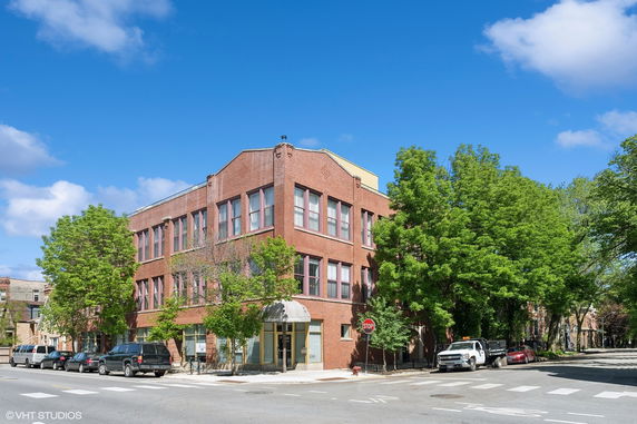 Front view of a two-story brick commercial building on a street corner.