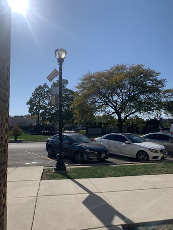 Outdoor parking area with parked cars and a nearby streetlamp.