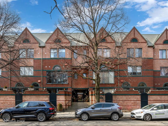Front view of a multi-story residential building with multiple gabled roofs.