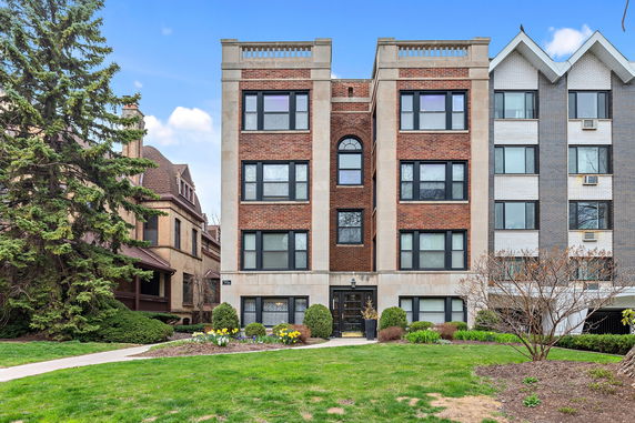 Front view of a multi-story apartment building with a brick facade.