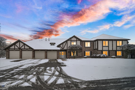 Front view of a two-story house with a triple garage and snow-covered surroundings.