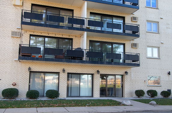 Front view of a multi-story apartment building with balconies.