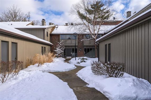 Front view of a two-story building with snow-covered path and surrounding.
