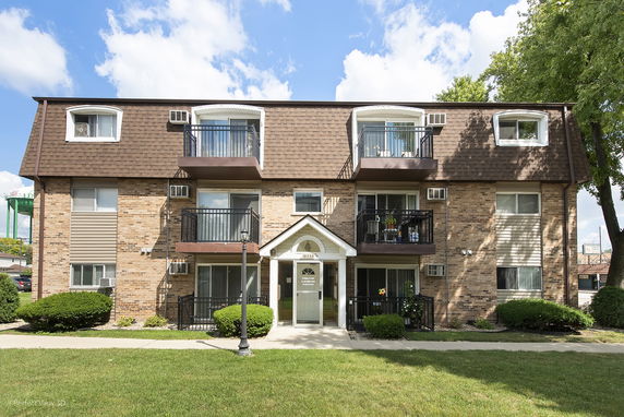 Front view of a multi-story residential building with balconies.