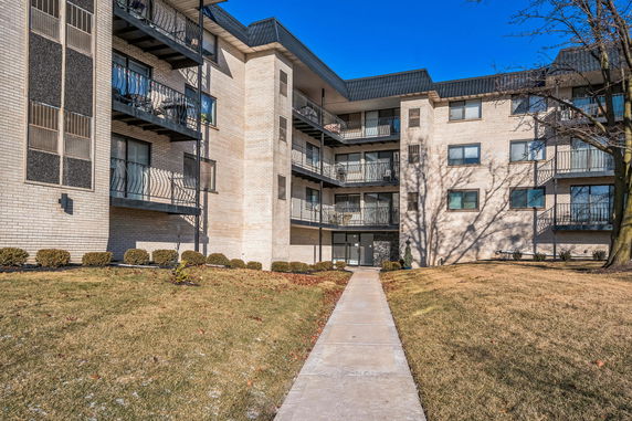 Front view of a multi-story apartment building with balconies.