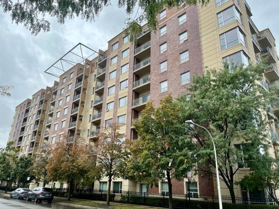 Front view of a multi-story apartment building with balconies.