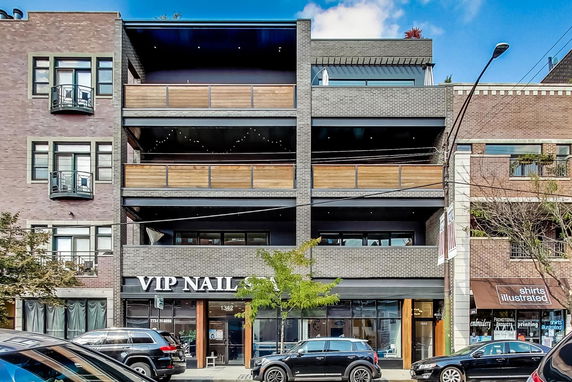 Front view of a multi-story building with retail space on the ground floor.