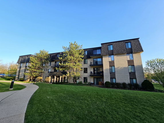 Front view of a multi-story apartment building with balconies.