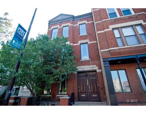 Front view of a multi-story brick building with tall windows and distinct doors.