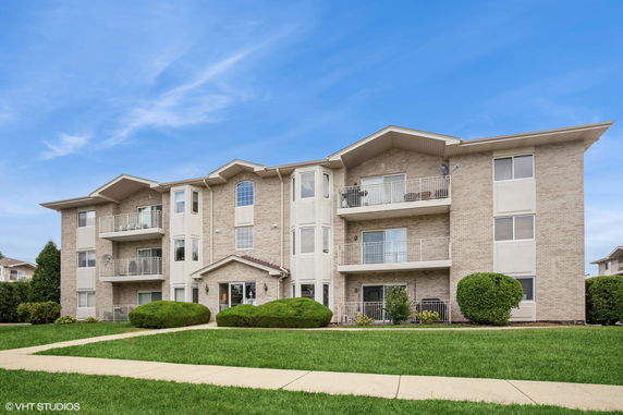 Front view of a multi-story apartment building with balconies.