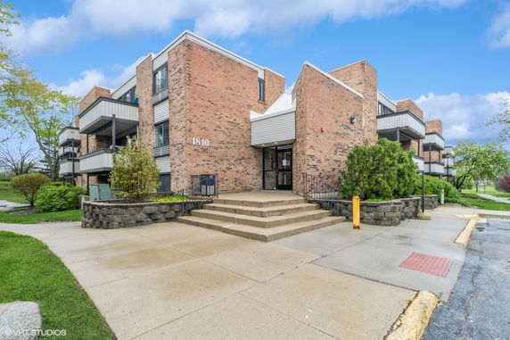 Front view of a brick multi-story building with balconies.