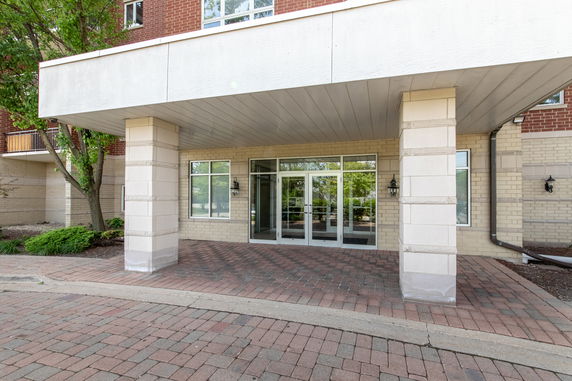 Front view of a building entrance with glass doors and large columns.