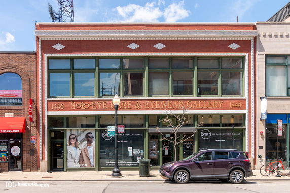 Front view of a two-story commercial building with large windows and a brick facade.