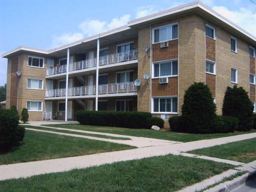Front view of a multi-story apartment building with balconies.