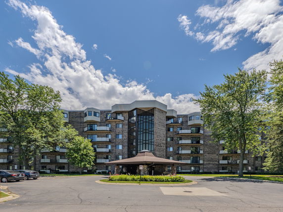 Front view of a multi-story building with large windows and balconies.