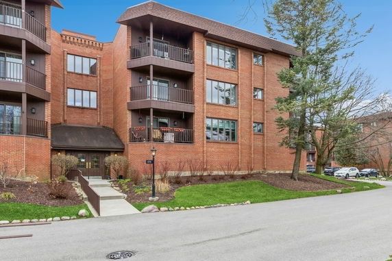 Front view of a multi-story brick apartment building with balconies.