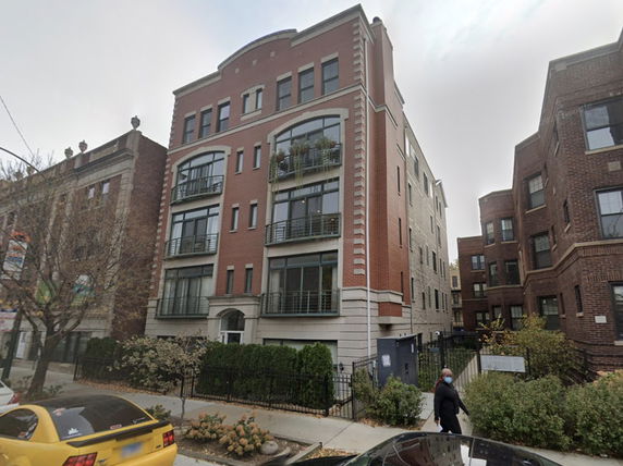Front view of a multi-story residential building with brick exterior.