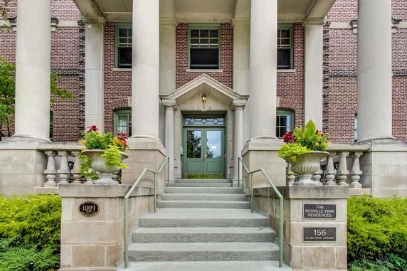 Front view of a building with large columns and brick facade.