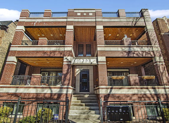 Front view of a multi-story brick building with balconies.