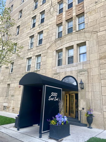 Front view of a multi-story stone building with an entrance canopy labeled '5000 East End'.