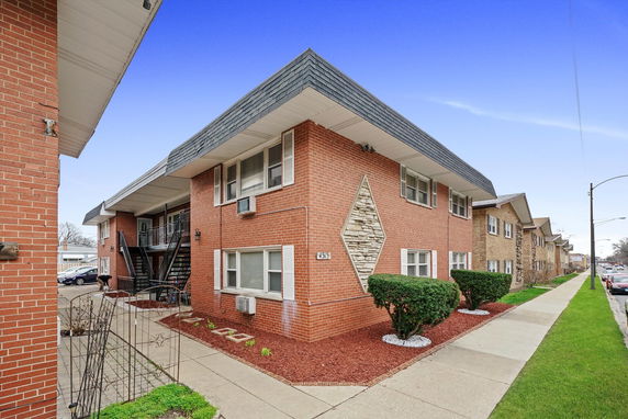 Front view of a two-story brick building with a triangular stone detail.
